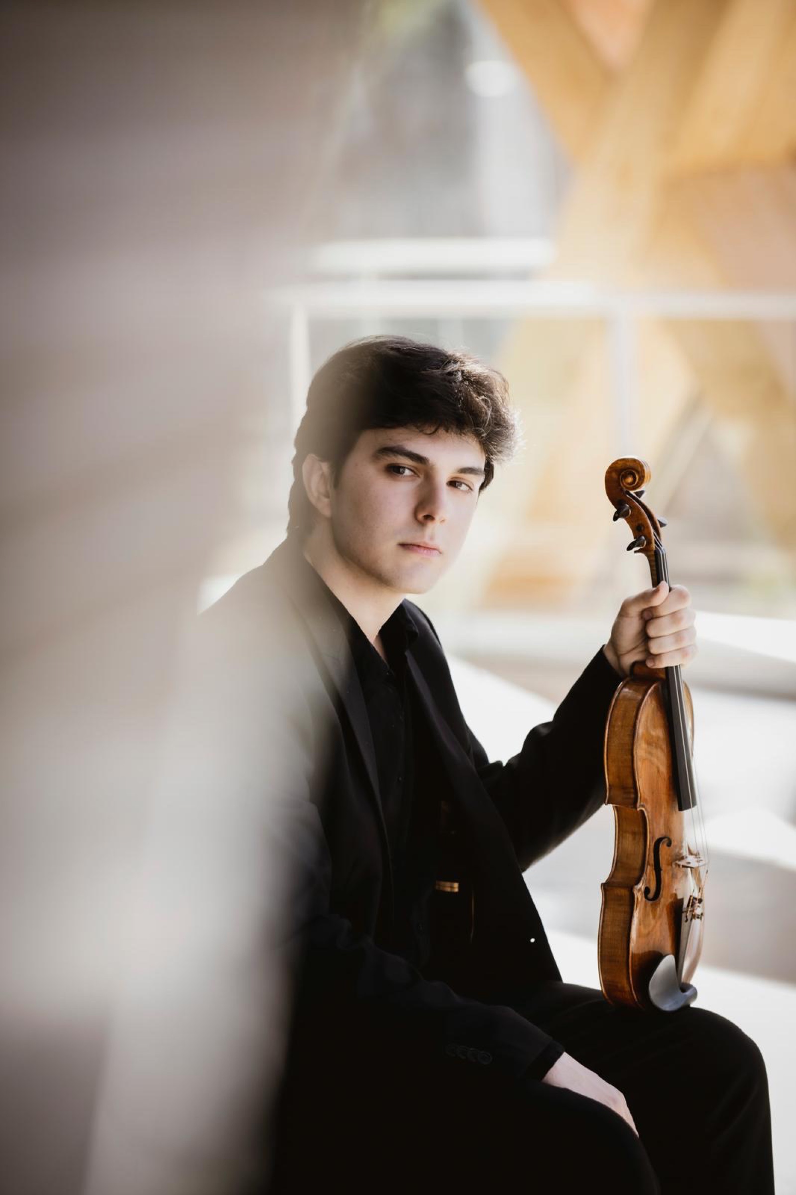 Portrait de Gabriel Rostagni tenant son violon dans une lumière claire